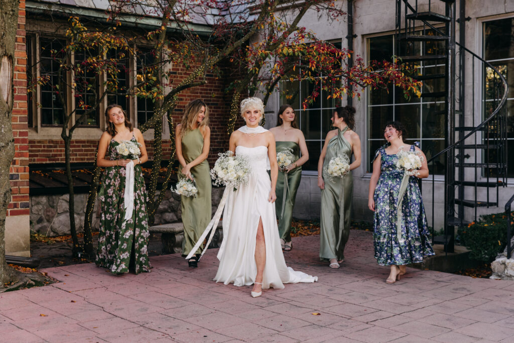 Bride with bridesmaids in elegant dresses outdoors.