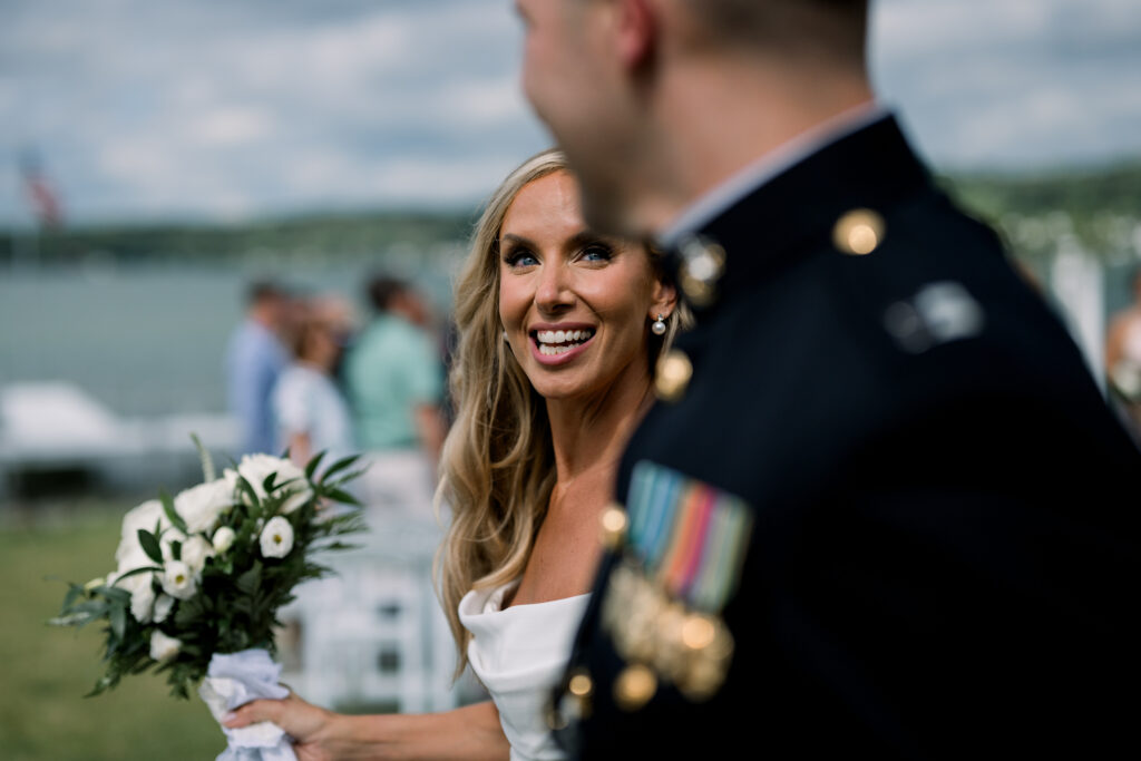 Smiling bride holding flowers during wedding ceremony.