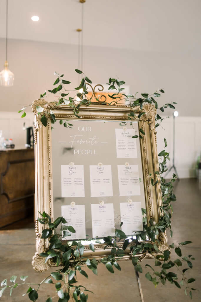 Ornate seating chart with greenery at an event