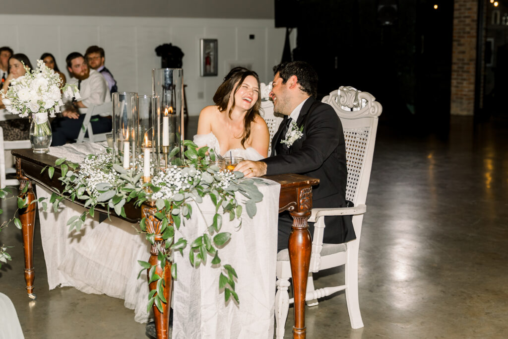 Happy couple at wedding reception table.